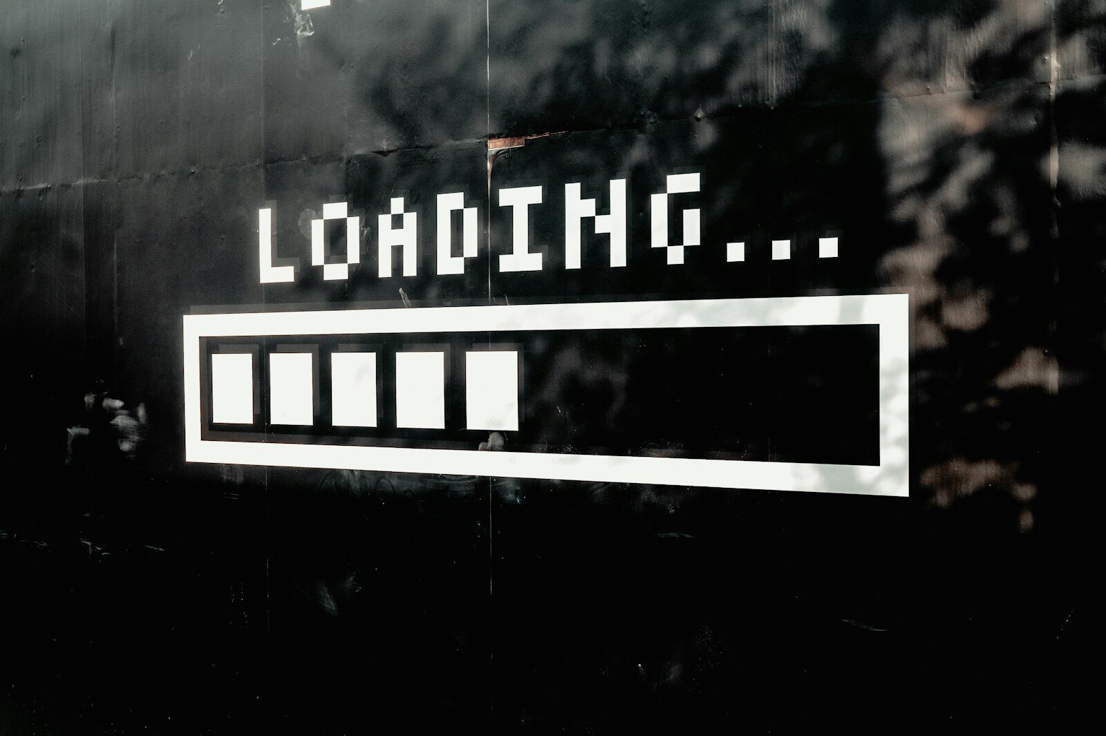 A white loading bar with five filled segments on a black wall